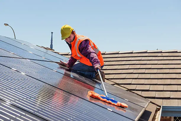 Technician cleaning solar panels