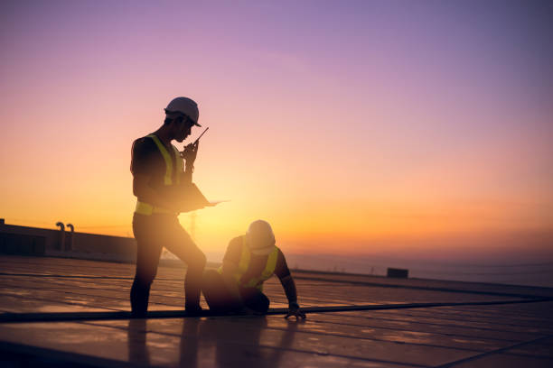 Technician inspecting solar panels at dawn